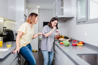 Young woman having food at home