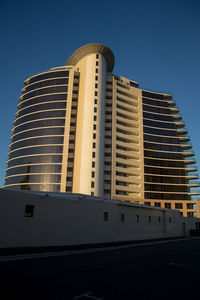 Low angle view of modern building against clear blue sky