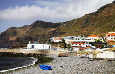 Houses on mountain against cloudy sky