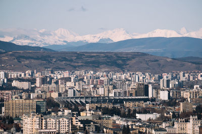 Aerial view of city and mountains against sky