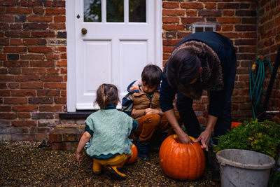 Side view of woman holding pumpkin