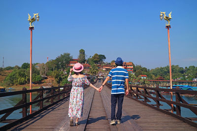 Rear view of people on railing against clear sky