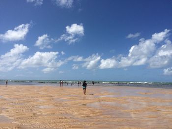 People swimming in sea against sky