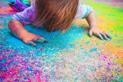 Girl playing with multi colored powder paint