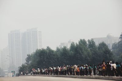 Group of people in park against buildings in city