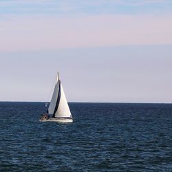 Sailboat sailing on sea against sky