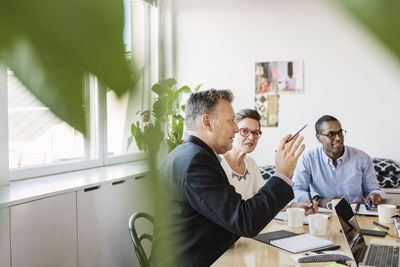 Mature businessman explaining multi ethnic colleague during meeting