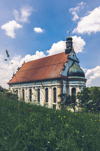 Building on field against sky