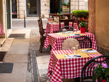 Chairs and tables at sidewalk cafe amidst buildings