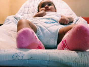 Full length of baby girl lying on bed