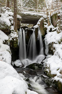 Scenic view of waterfall in forest during winter