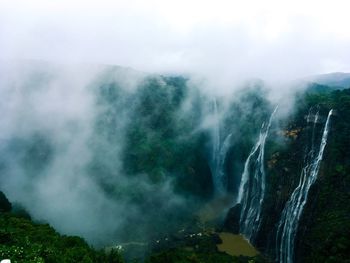 Scenic view of waterfall against sky