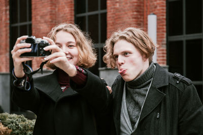 Close-up of friends photographing in city