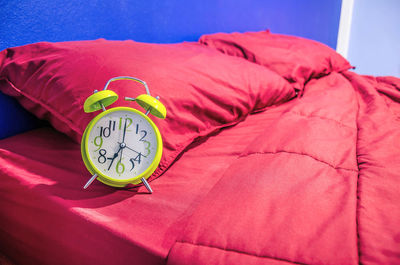 Close-up of alarm clock on bed