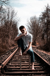 Full length of man standing on railroad track against sky