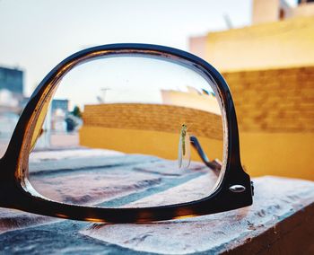 Close-up of sunglasses on side-view mirror