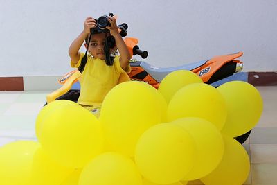 Boy with toy motorcycle by balloons
