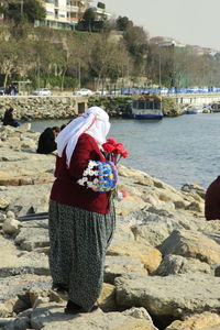 Rear view of woman standing on shore