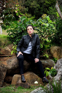 Portrait of young woman sitting on rock