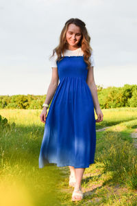 Portrait of smiling young woman standing on field