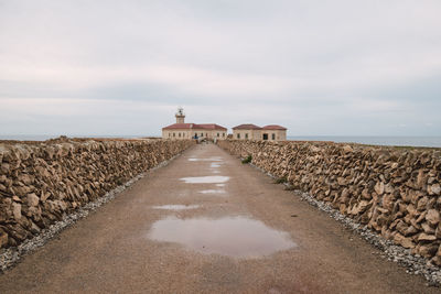 Footpath by sea against sky