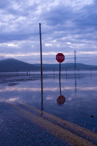 Road sign against sky