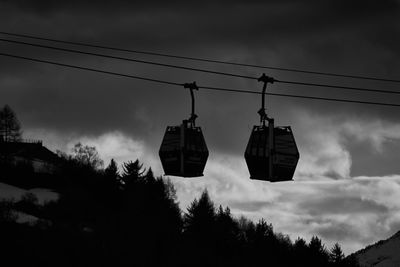 Low angle view of overhead cable cars against sky