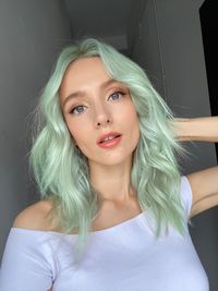 Portrait of young woman with green hair