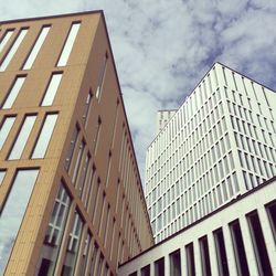 Low angle view of modern building against cloudy sky