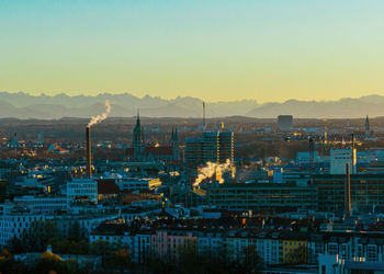 Illuminated cityscape against sky during sunset