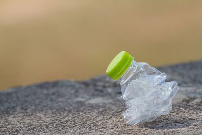 Close-up of crushed bottle on rock