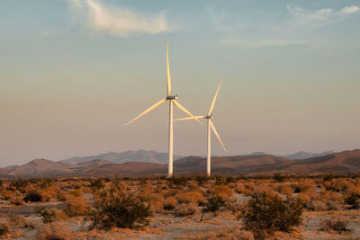 Wind turbines on land against sky