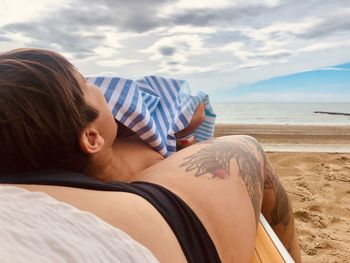 Rear view of woman and a baby relaxing at beach