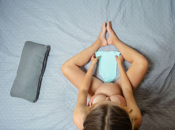 High angle view of woman lying on bed at home