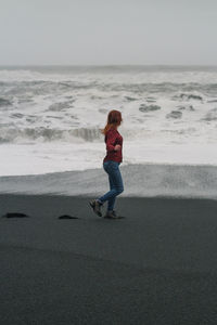 Woman walking along black iceland beach scenic photography