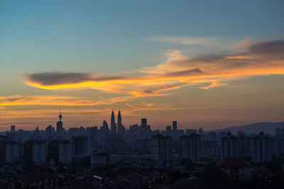 View of cityscape against cloudy sky during sunset