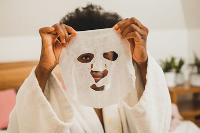 Midsection of woman holding mask