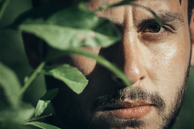 Close-up portrait of man by plant