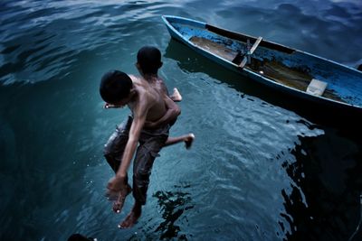 High angle view of boys jumping into water