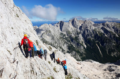 Low angle view of people on mountain against sky