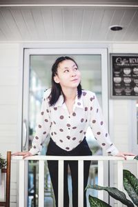 Portrait of beautiful young woman standing at home