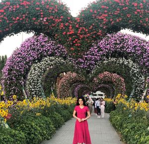 People standing by purple flowering plants