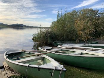 Boats moored in lake against sky