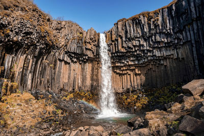 Scenic svartifoss waterfall amidst basalt columns in national park against sky