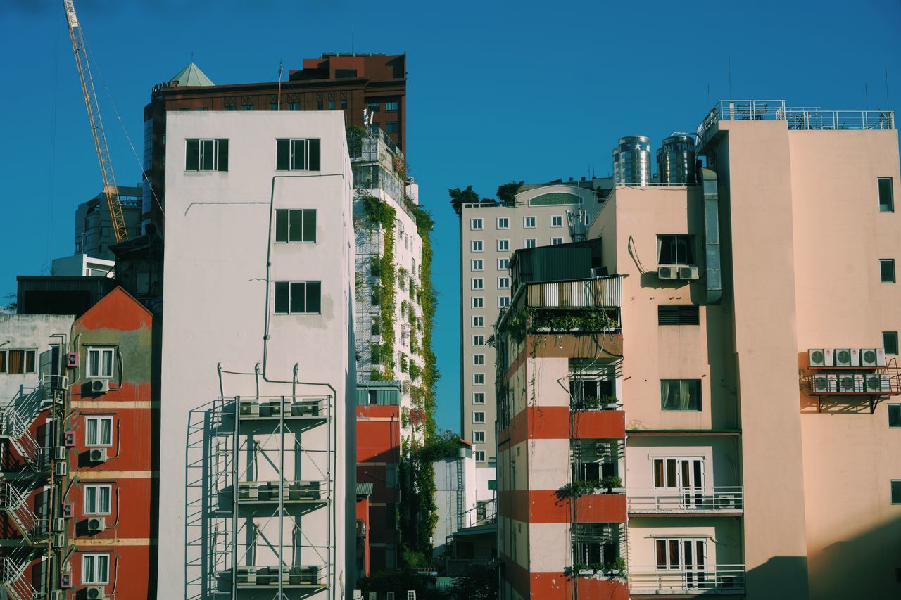 building exterior, architecture, built structure, building, residential district, city, sky, nature, no people, clear sky, day, outdoors, window, sunlight, apartment, low angle view, blue, town, balcony, city life