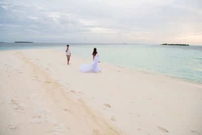 People on beach against sky