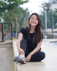 Smiling young woman sitting outdoors