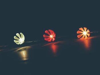 Close-up of illuminated lights on table against black background
