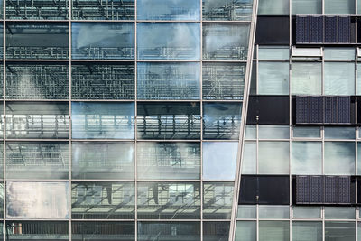 Low angle view of glass building against sky