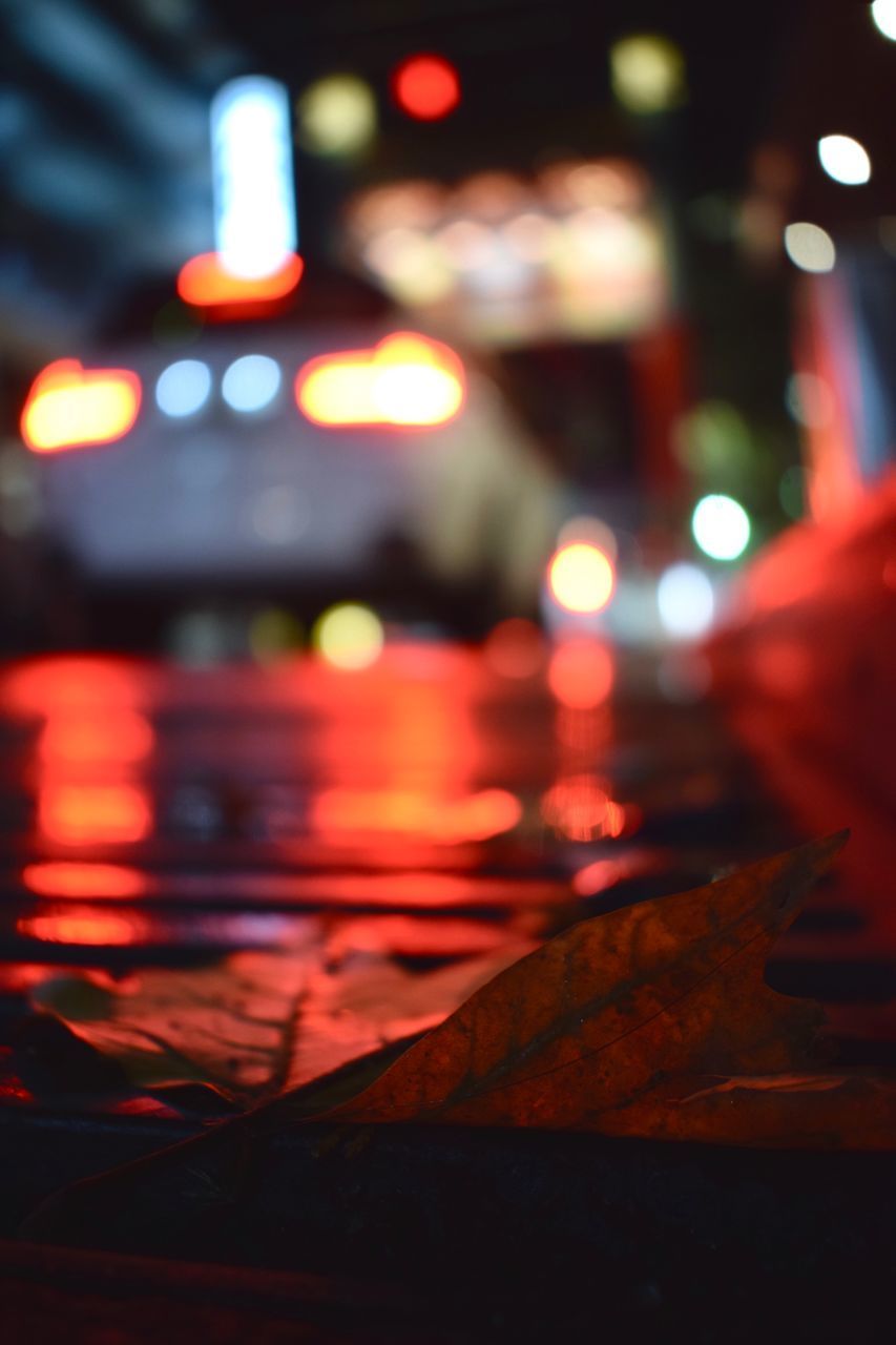 CLOSE-UP OF ILLUMINATED LIGHTS AT CITY STREET